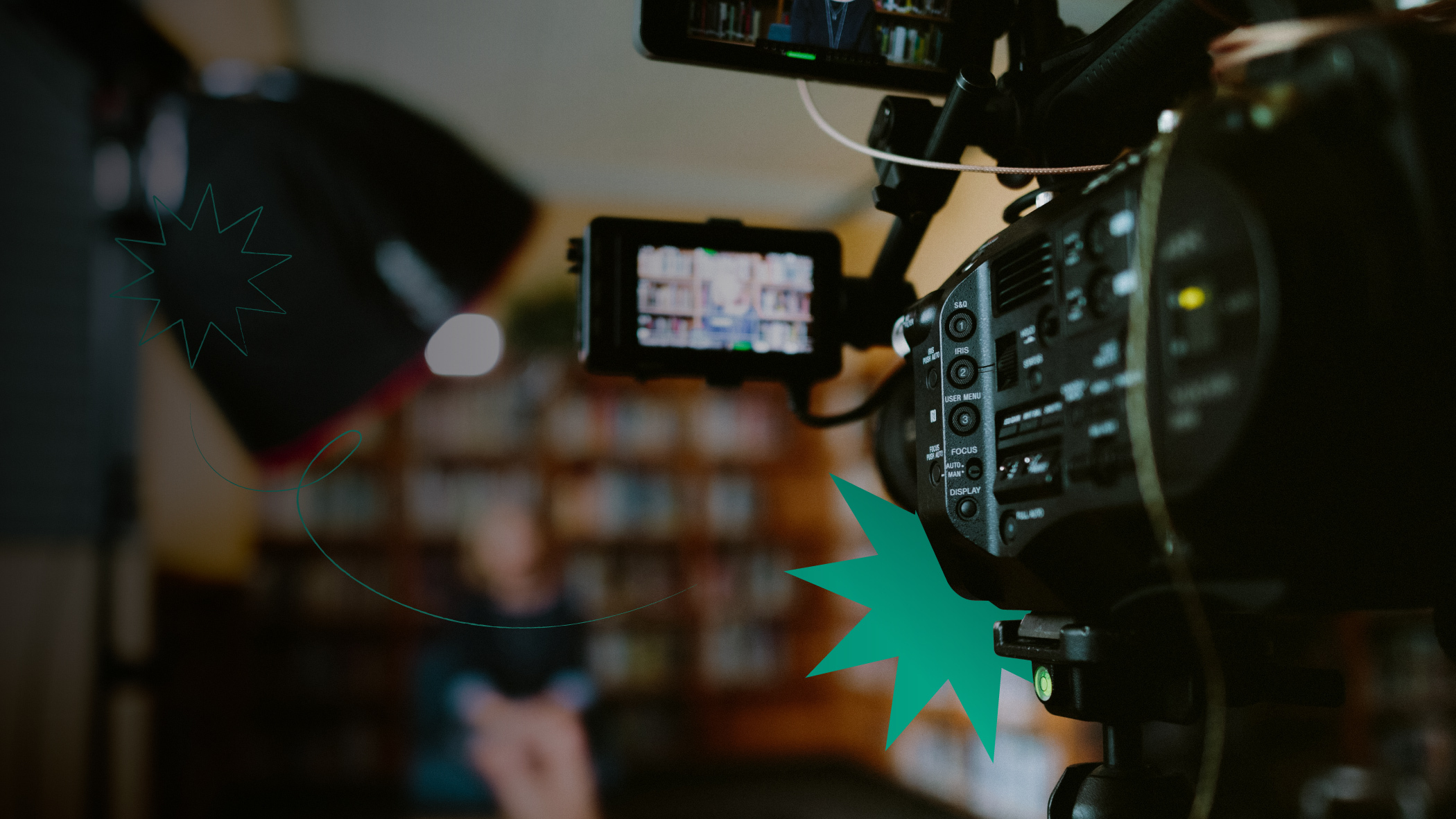 A camera filming a woman with bookshelves on the background